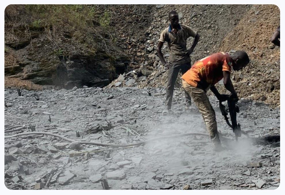 Workers using a pneumatic drill at a mining site