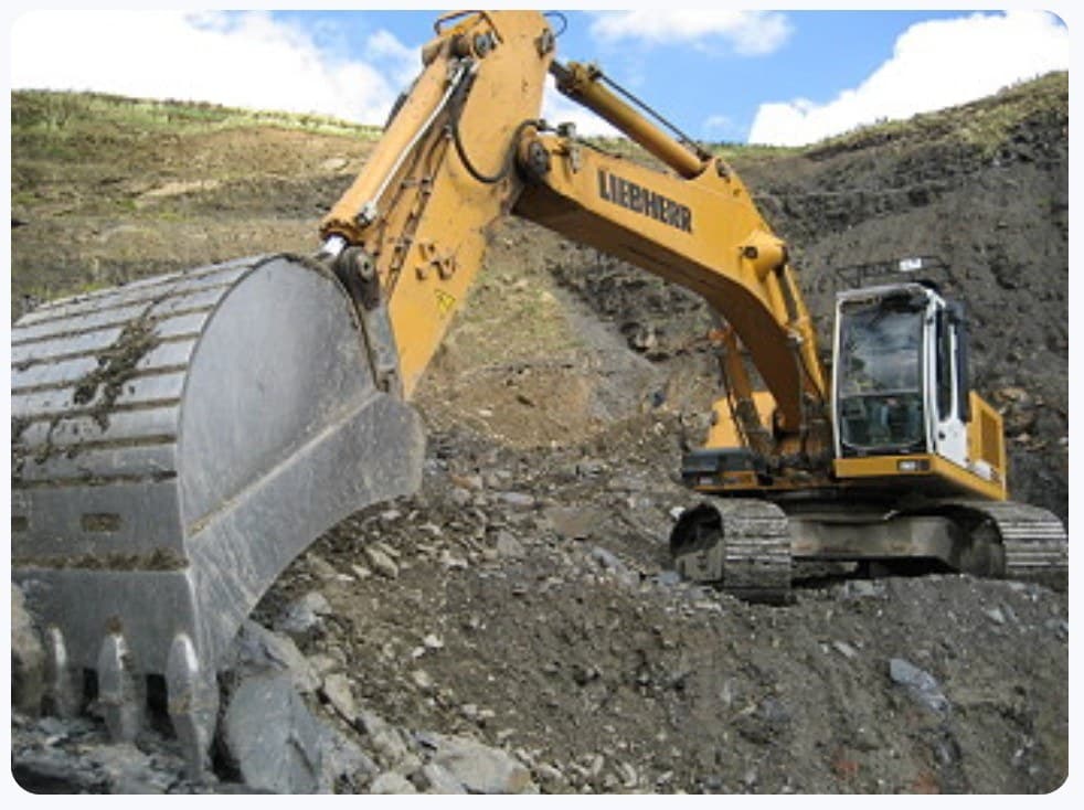 Yellow Liebherr excavator working on a rocky mining slope
